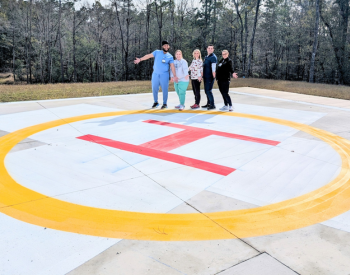 Washington County Hospital and Nursing Home Staff standing outside over the H where the hospital helicopter lands
