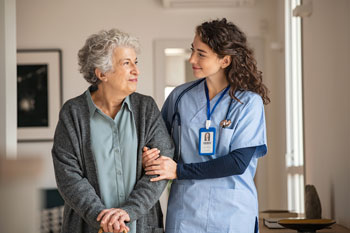 female nurse helping elderly patient
