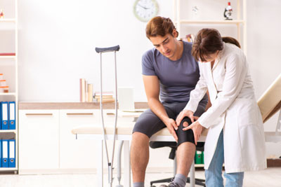 Young male patient visiting female doctor traumatologist
