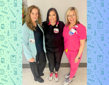 4 Lab workers standing in the hallway of the hospital. Wearing "Saved by the Lab" shirts and scrub pants.
